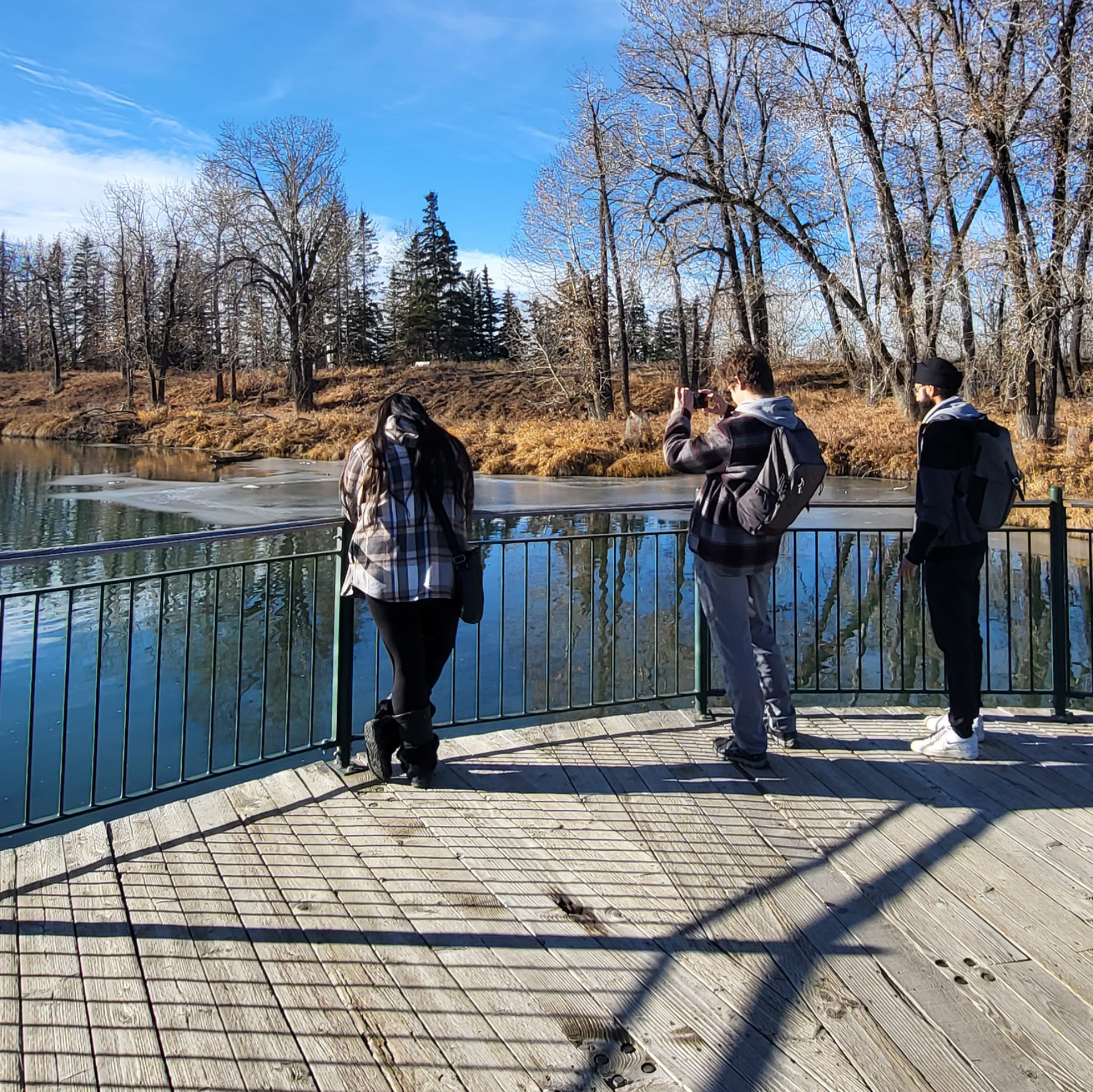 Three people overlooking a lake